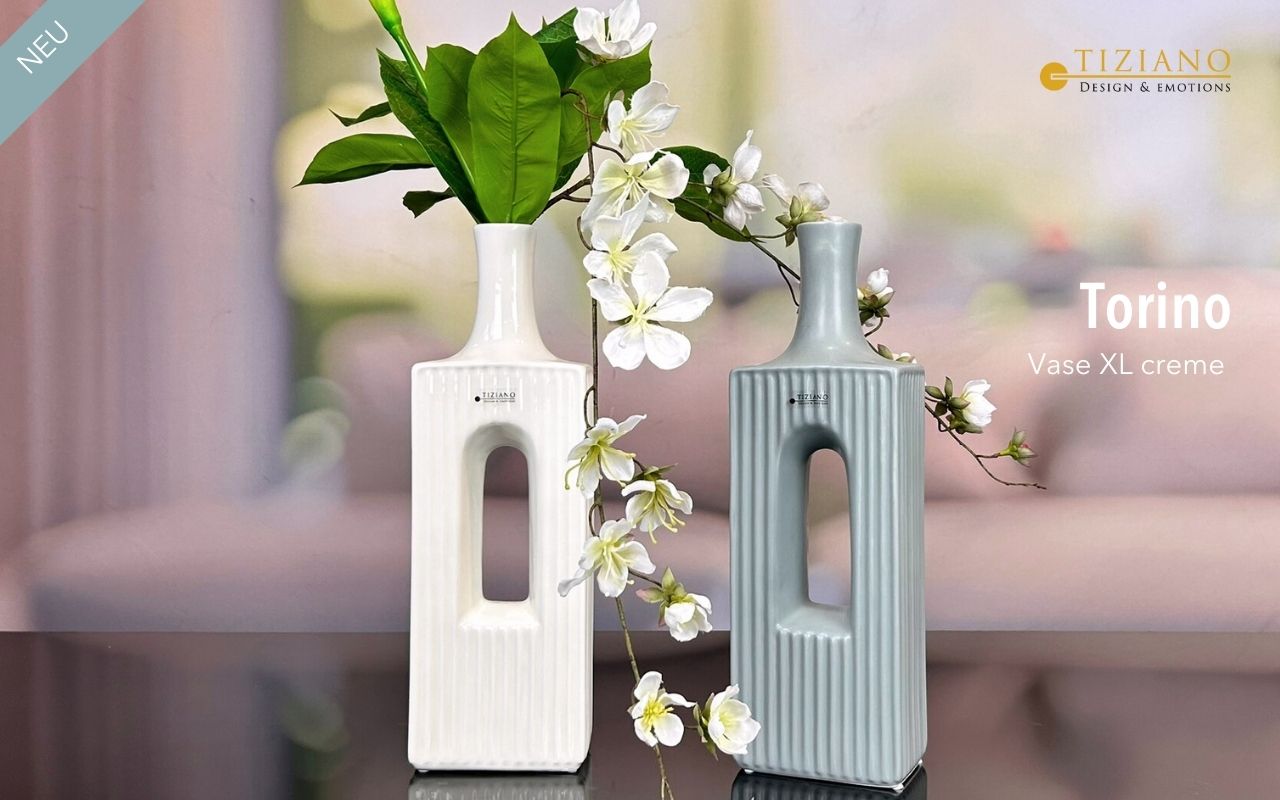 Stilvolle Torino XL-Vasen in Creme und Grau mit modernem Design mit vertikaler Riffelung und zentraler Öffnung, verziert mit grünen Blättern und weißen Blumen, perfekt für die Inneneinrichtung.