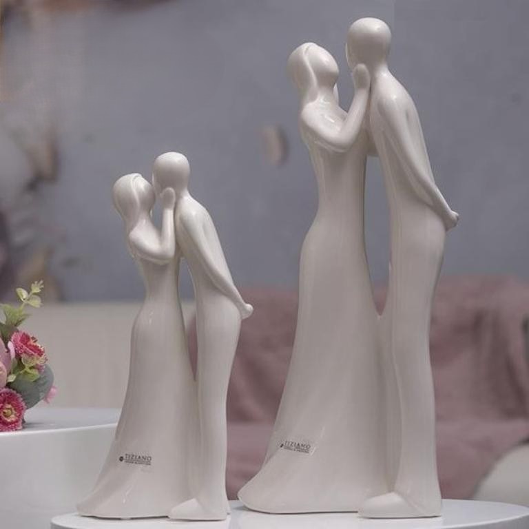 Dekorative Figuren eines Paares in inniger Umarmung, in elegantem Design und cremigen Farbton.