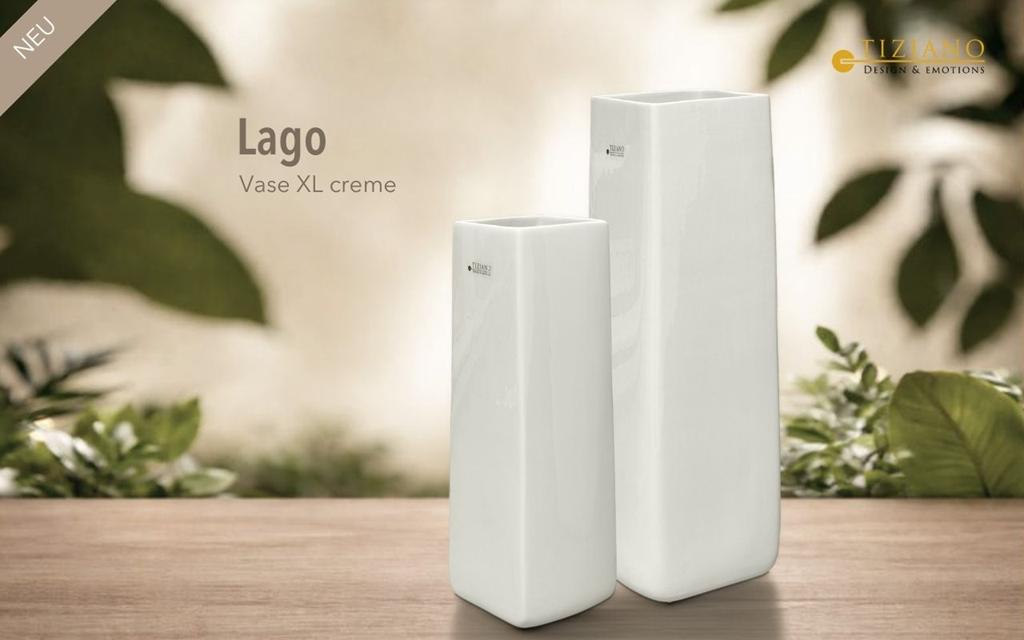 Die eleganten cremefarbenen Lago XL-Vasen auf einer Holzoberfläche, umgeben von üppigem Grün, präsentieren modernes Design und Raffinesse für die Inneneinrichtung.
