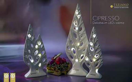 Ein Set aus drei eleganten cremefarbenen Cipresso-Dekobäumen aus Keramik von Tiziano mit aufwendigen Ausschnittdesigns und warmer integrierter LED-Beleuchtung für eine anspruchsvolle Urlaubsdekoration.