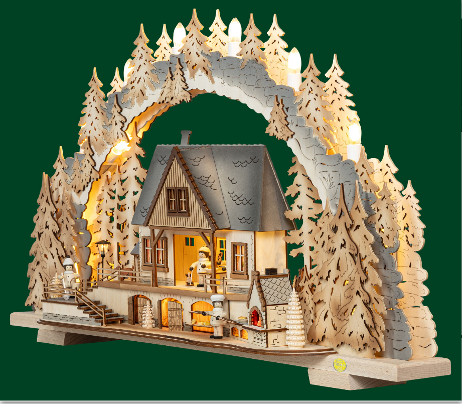 Ein traditioneller, handgefertigter deutscher Weihnachtsbogen aus Holz mit einer beleuchteten Alpenhausszene mit Miniaturfiguren, Kiefern und warmer LED-Beleuchtung, perfekt für die festliche Weihnachtsdekoration.