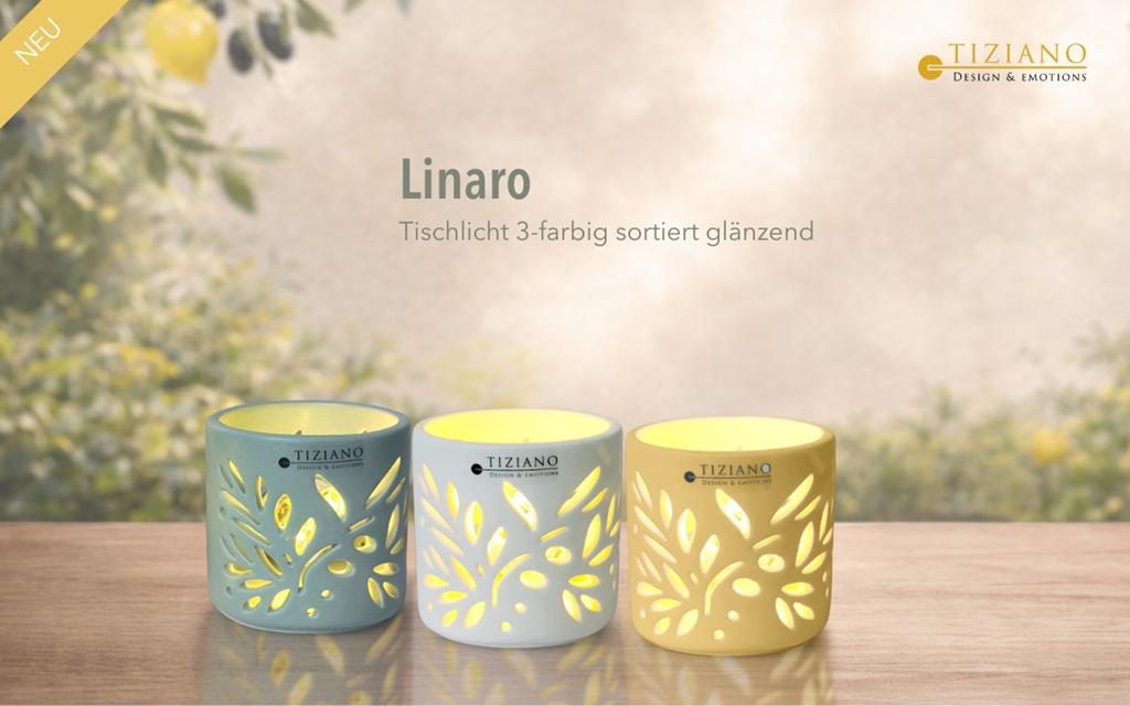 Drei glänzende Tischlichter mit floralen Aussparungen in verschiedenen Farben auf Holztisch