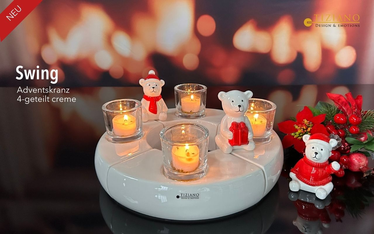 Ein cremefarbener Keramik-Adventskranz von Tiziano mit vier Kerzenhaltern aus Glas mit brennenden Teelichtern, dekoriert mit drei süßen Keramik-Teddybären in roter Winterkleidung und einem festlichen Weihnachtsstern-Arrangement vor einem verschwommen