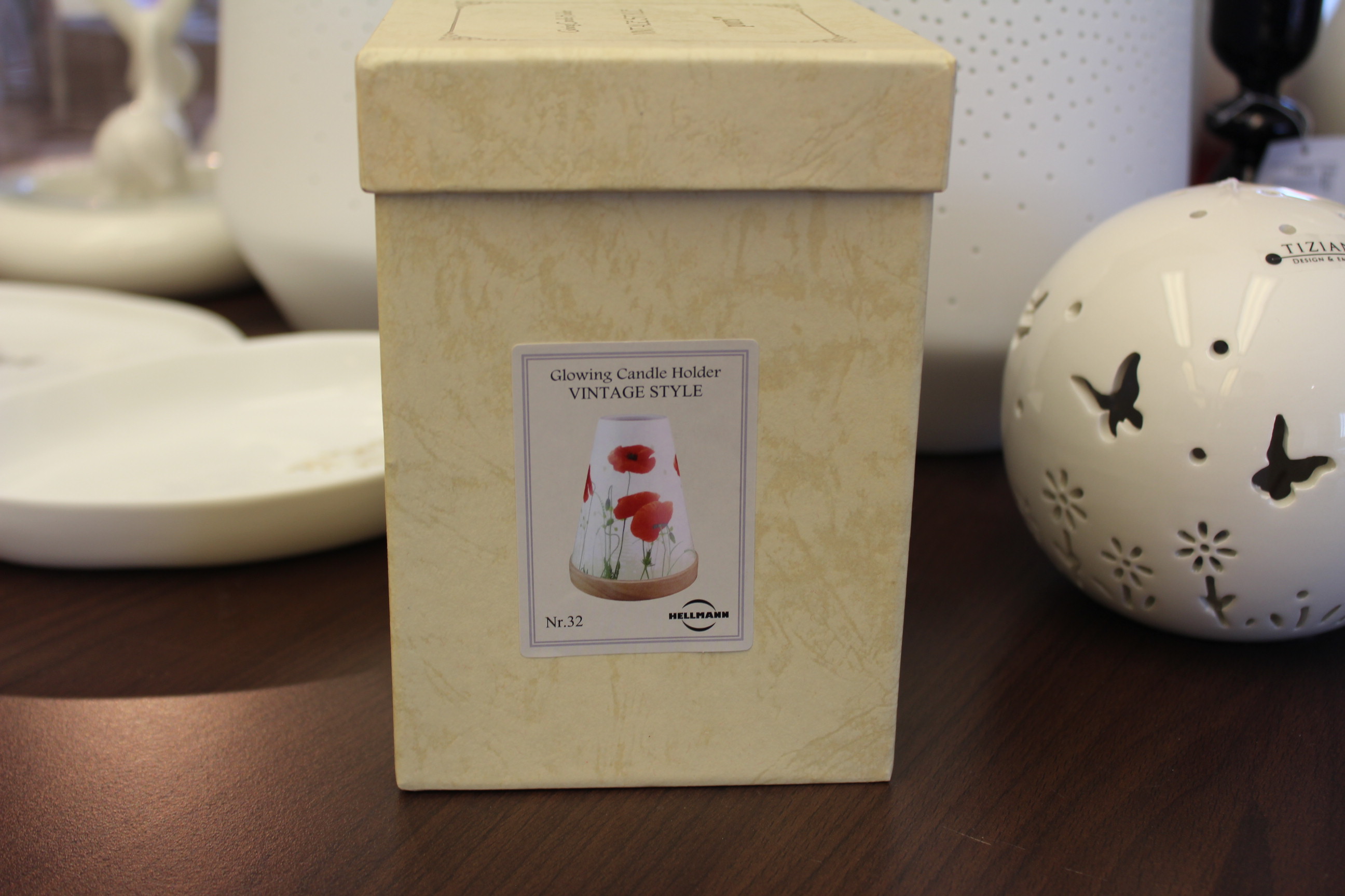 Leuchtender Kerzenhalter im Vintage-Stil in dekorativer Box auf Holztisch.